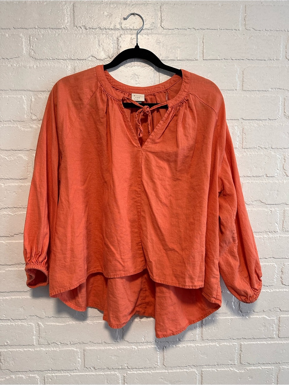 A New Day salmon pink blouse with tie front and balloon sleeves.